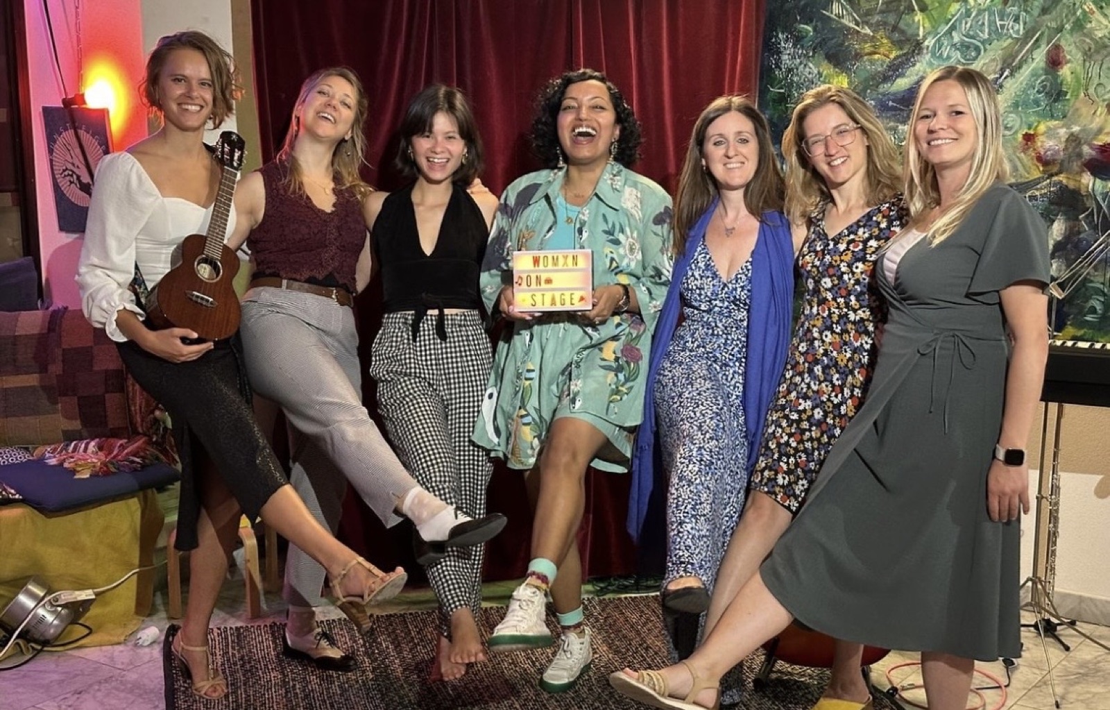 Womxn on Stage — performer with ukulele and cast holding the Womxn on Stage sign at Ekstase, Zurich